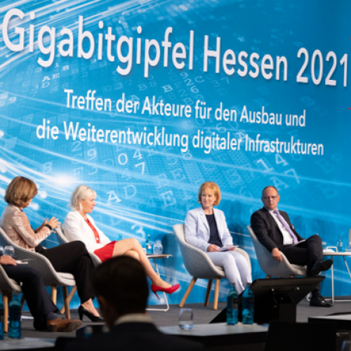 Moderatorin mit 5 Panelgästen auf der Bühne