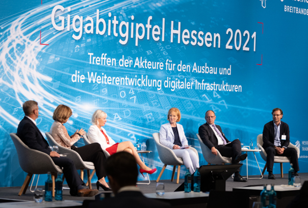 Moderatorin mit 5 Panelgästen auf der Bühne